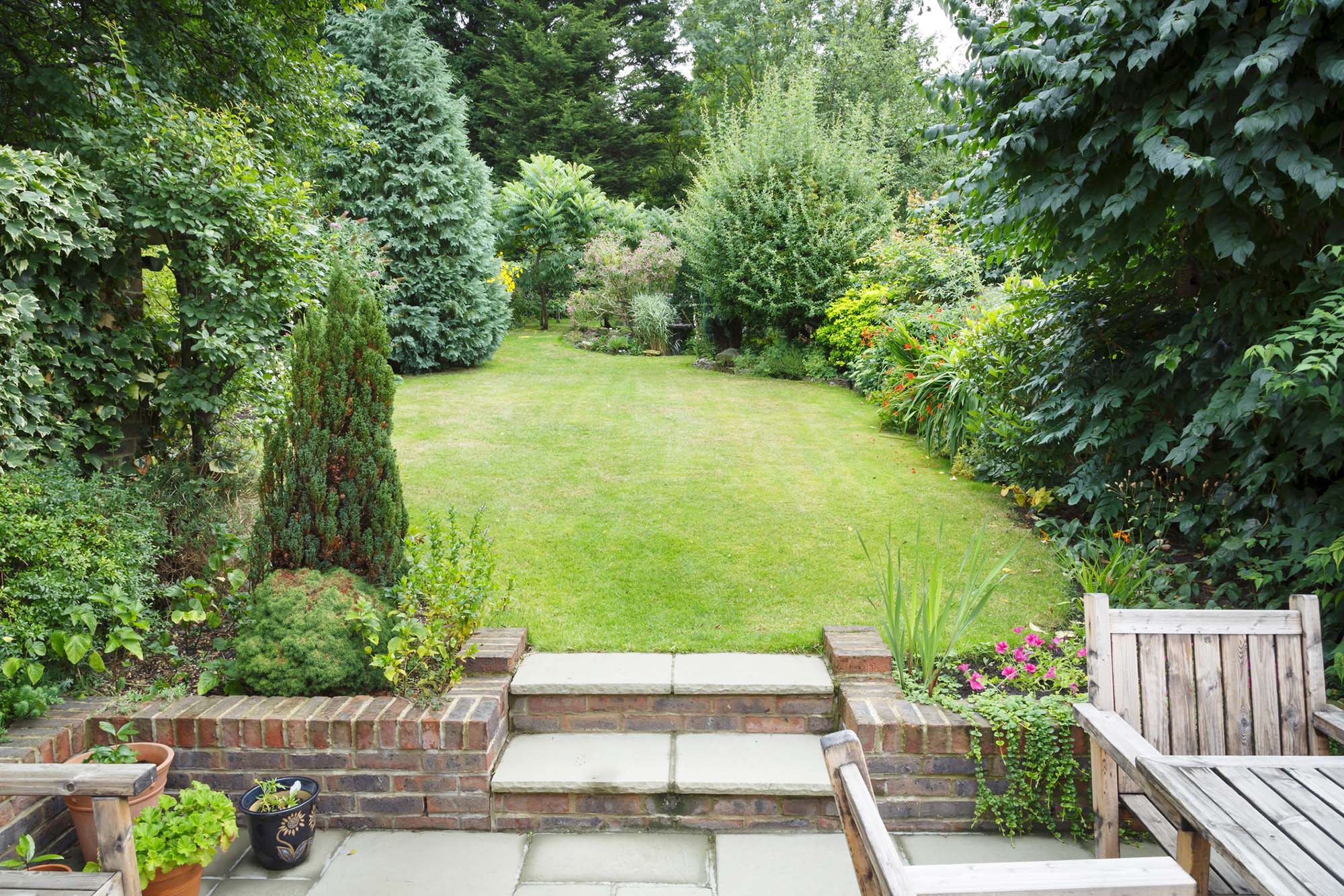 English back garden. Terraced and landscaped back garden in England UK with patio, grass and stone steps